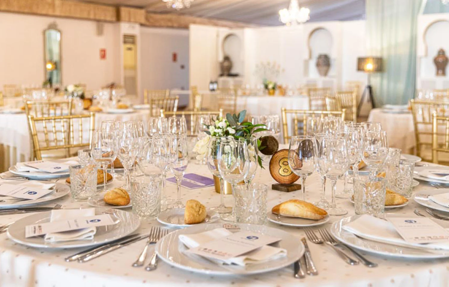 Mesas preparadas para banquete en el interior de un salón de celebraciones en Granada por La Mamunia catering