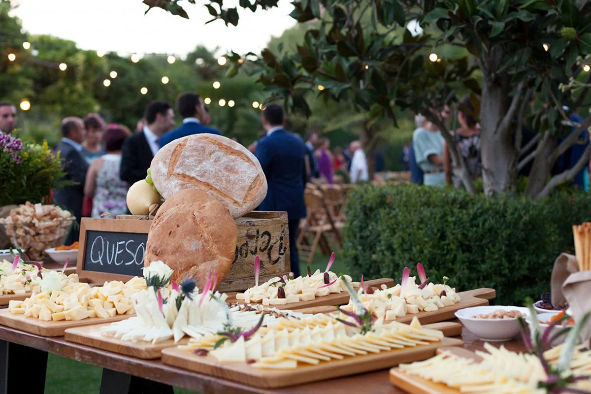 Diferentes tipos de quesos en evento al aire libre realizado por catering Alameda