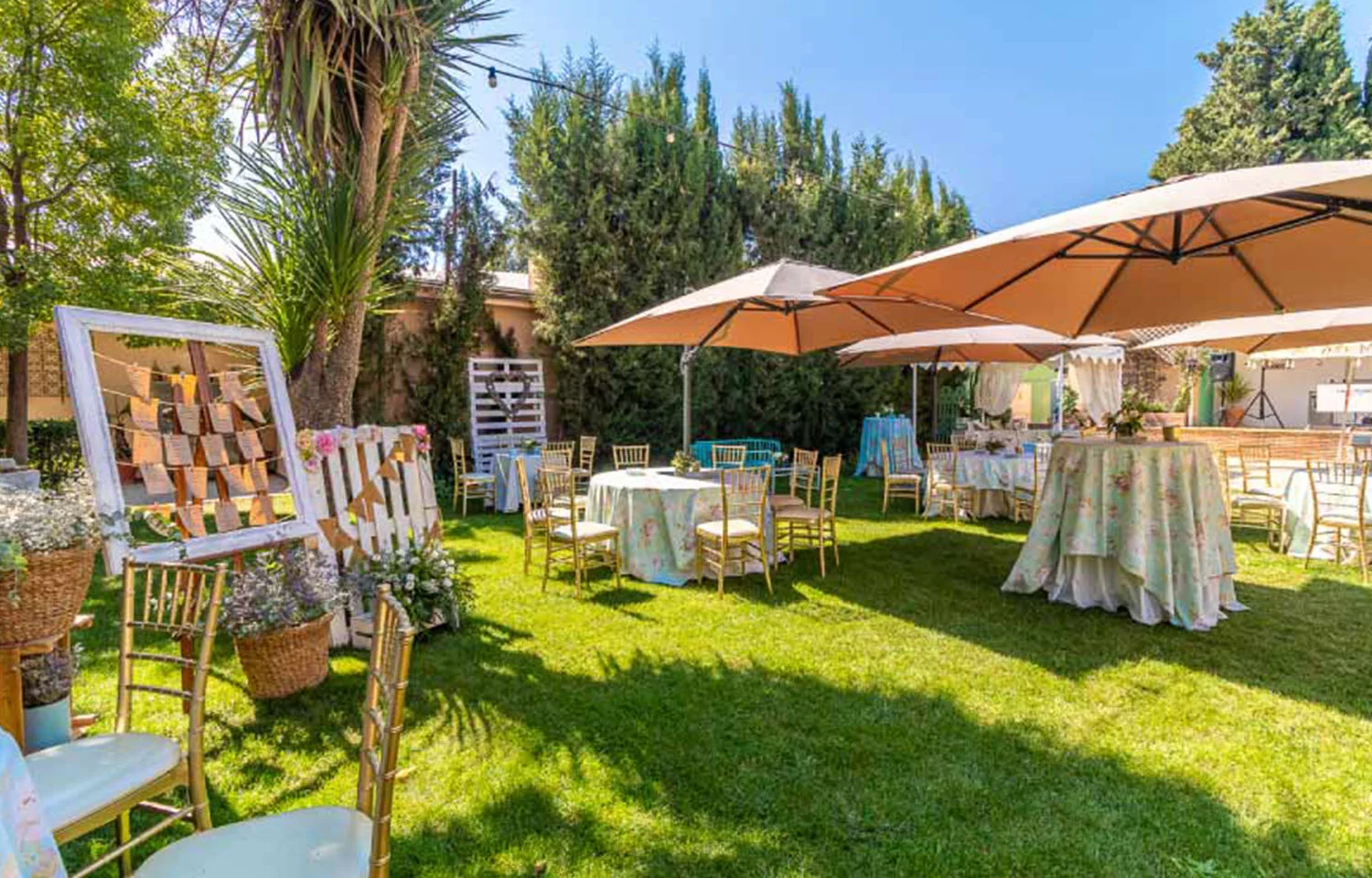 Decoración de jardín con mesas altas, sitting, flores y carpas en evento realizado por La Mamunia Catering