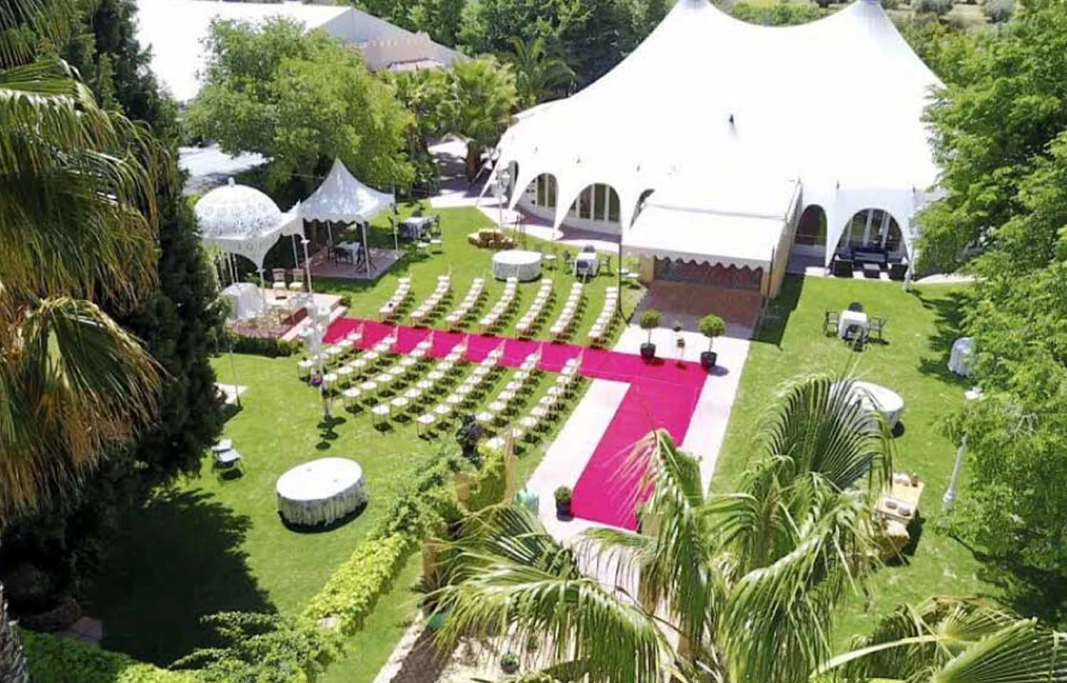 Vista aérea de evento realizado en los jardines exteriores de La Mamunia donde se aprecia alfombra roja, sillas y diferentes espacios