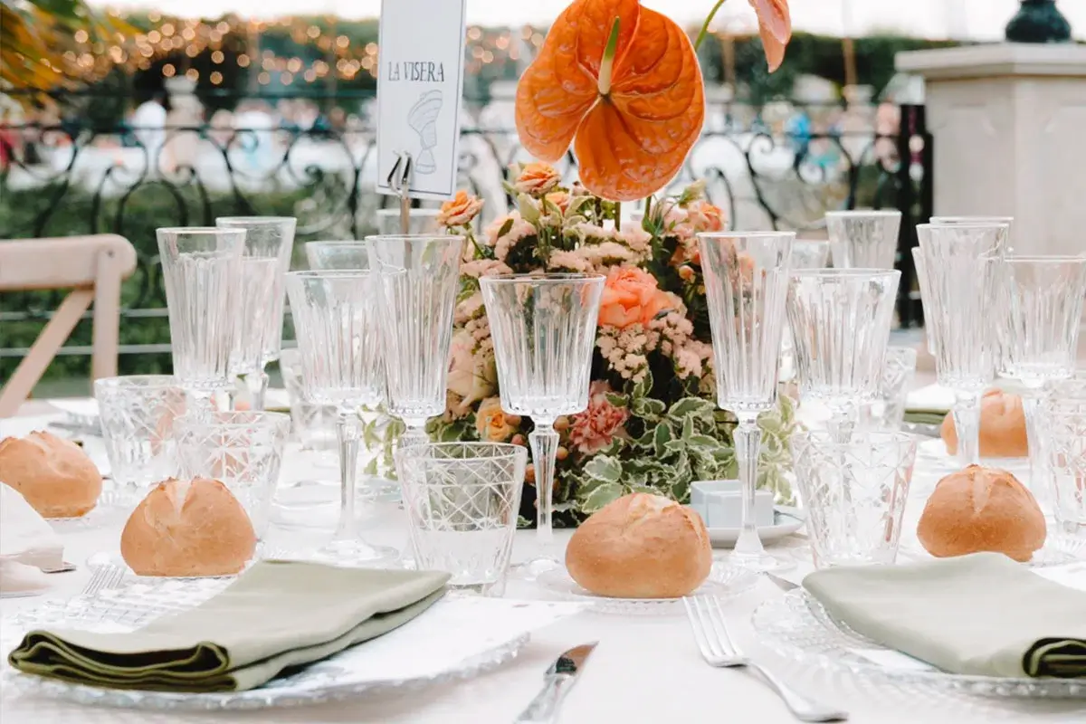Mesa preparada para evento de empresa al aire libre con cubertería, vajilla y decoración realizada por Catering Velázquez