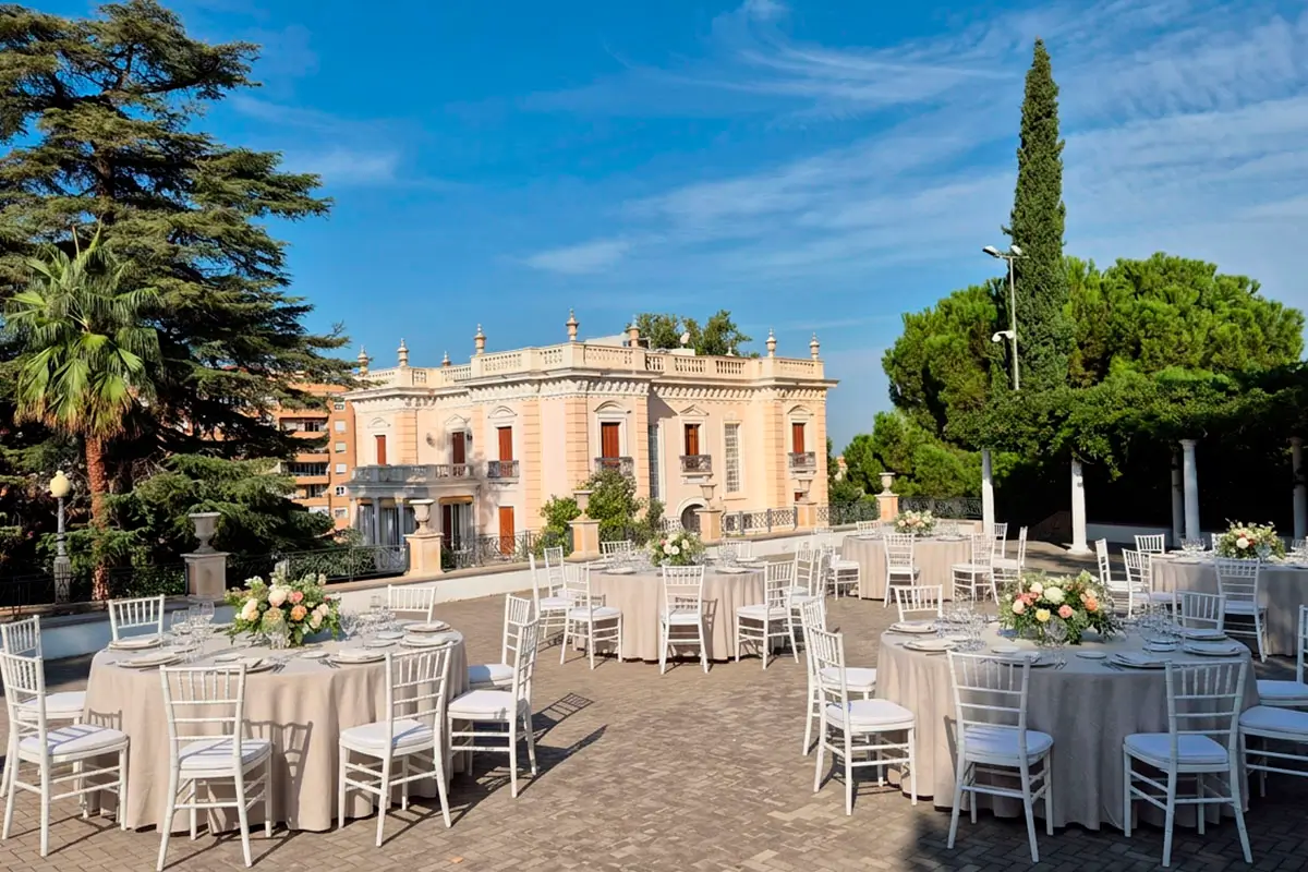 Celebración de boda al aire libre en el Palacio de Quinta Alegre Mesas decoradas preparadas para celebrar un banquete de boda en el Palacio de Quinta Alegre