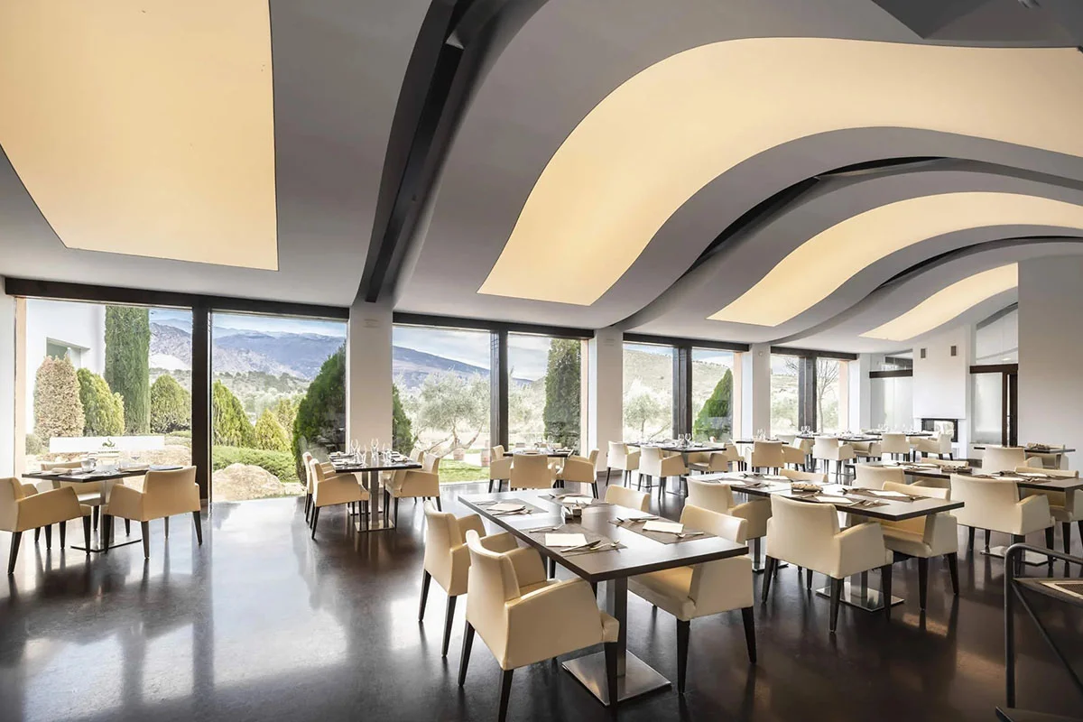Interior del restaurante con mesas preparada para cena en la Hacienda Señorío de Nevada