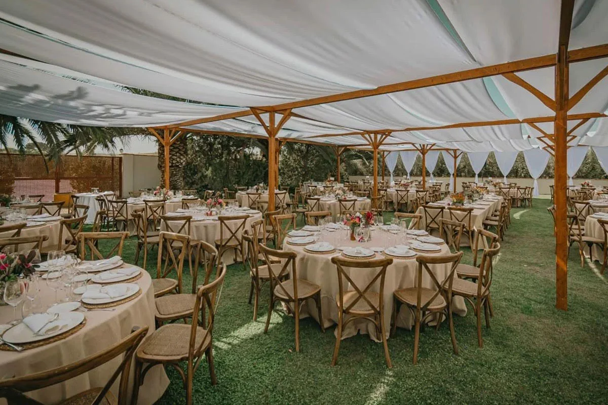Montaje de banquete en jardín con carpa decorativa
