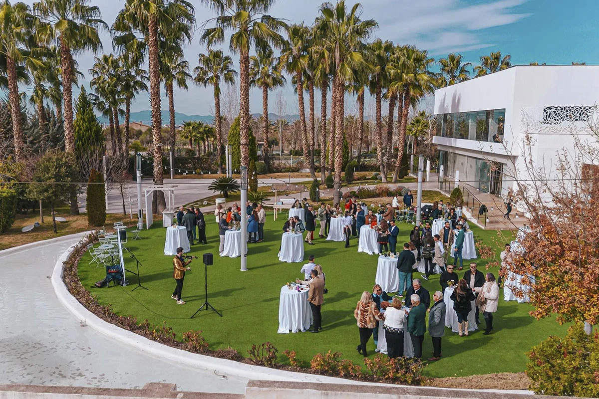 Celebración cóctel con música en vivo y asistentes disfrutando en los jardines de Siddharta