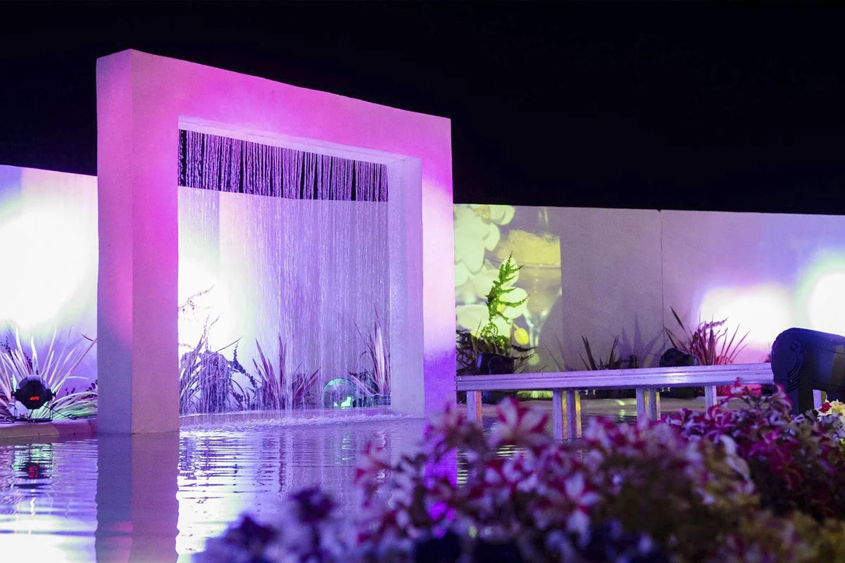 Fuente iluminada al anochecer en el exterior de Jardines de Siddharta