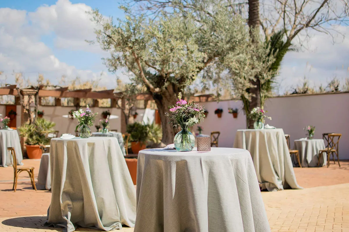 Mesas tipo cóctel en el Patio de los Olivos de Torre del Rey preparadas para celebración de cóctel de empresa