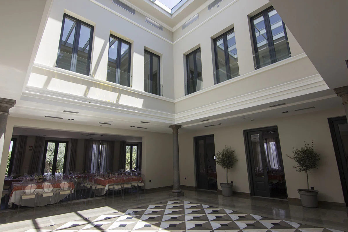 Vista interior de patio central y mesas para evento en la zona izquierda en el interior de Viñas de Belén