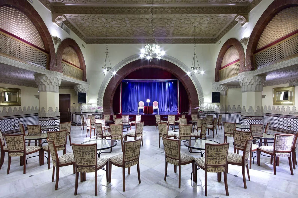 Mesas, sillas y escenario del teatro del Hotel Alhambra Palace
