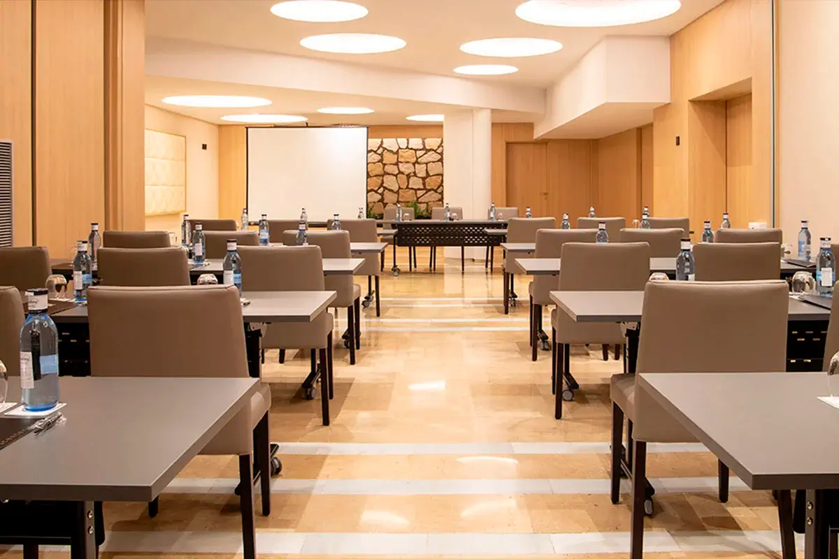Salón de eventos del hotel Granada Center con montaje en escuela para celebrar un evento empresarial