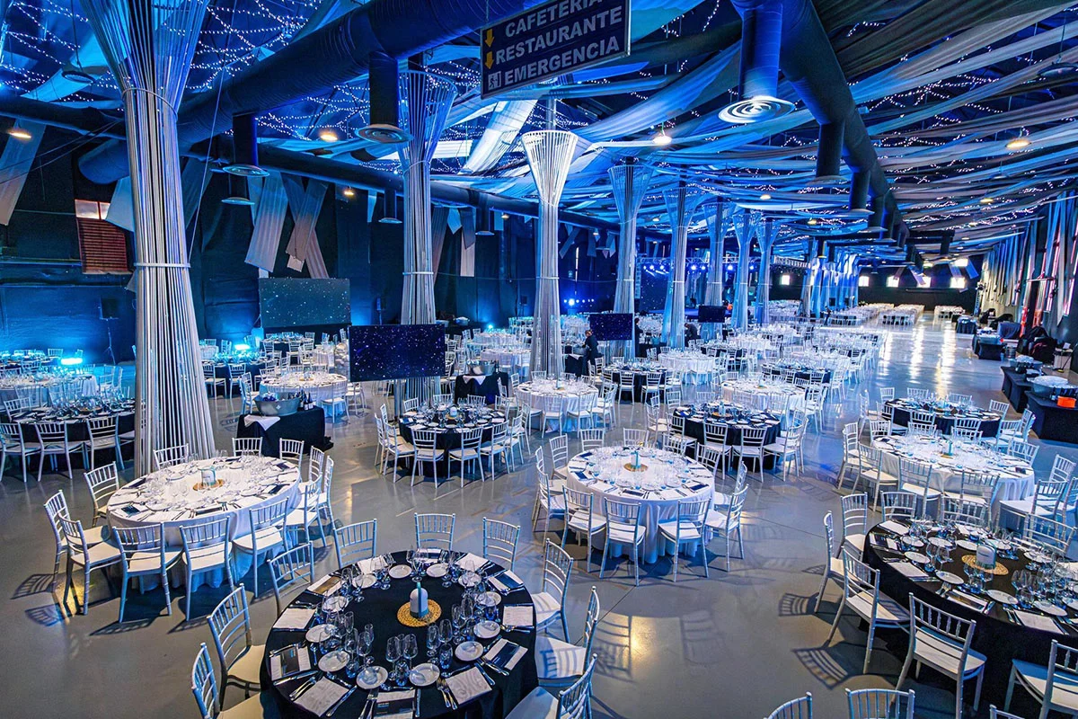 Gran cantidad de mesas y sillas ubicadas en el interior del salón de la azucarera para celebrar una gran cena de gala con muchos invitados